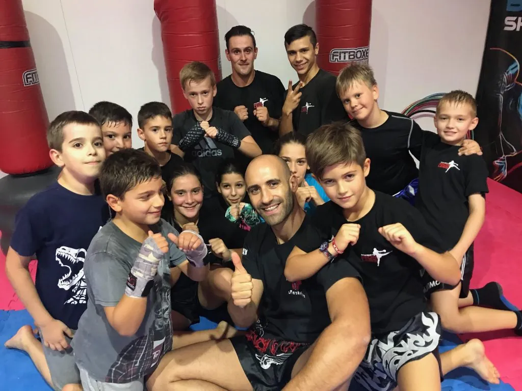 Turma de crianças da Iron Legs Academy com o treinador